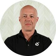 Dr. Peter Fotinos, MD, Physician at Fem Excel, smiling in black polo with arms crossed.