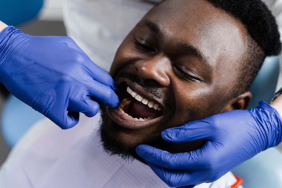 dental-health-heart-disease-dentist-examines-patient-teeth-with-blue-gloved-hands