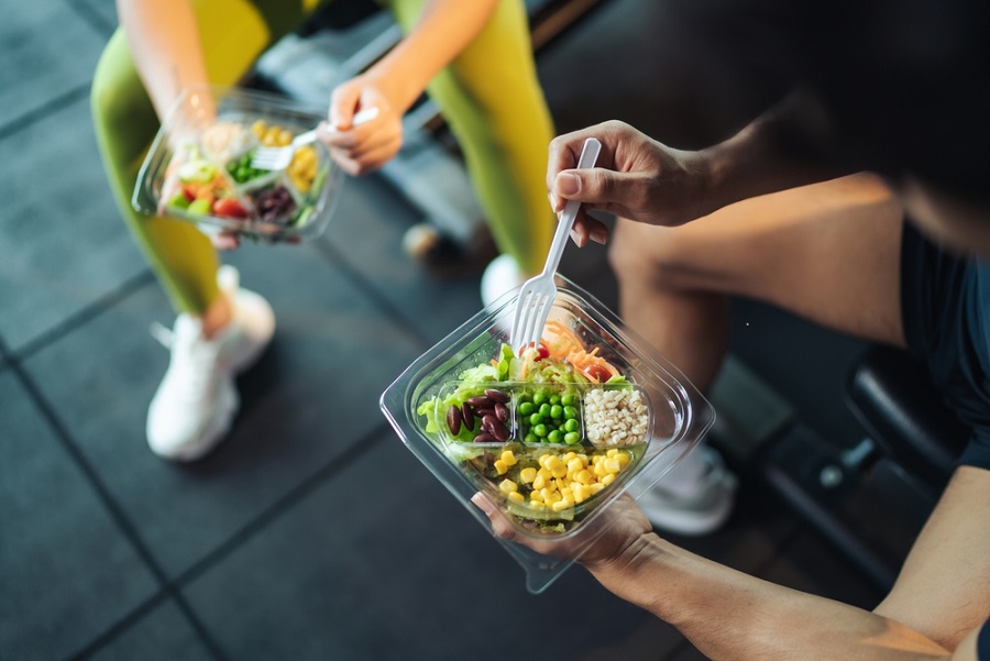 managing-chronic-pain-top-view-of-man-and-woman-eating-salad-after-exercising-in-gym