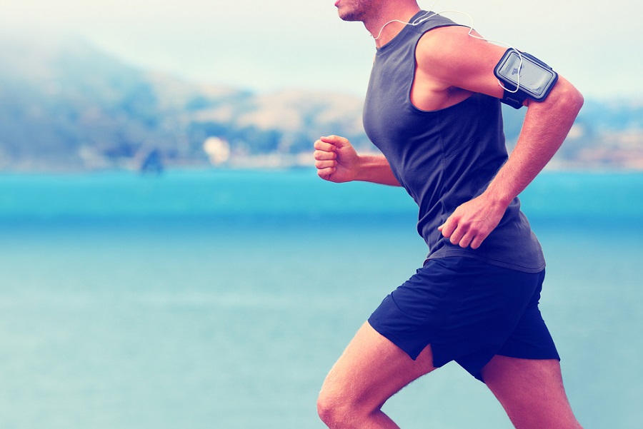 HRV-and-wellbeing-fit-man-running-with-smartphone-on-upper-arm-and-earphones
